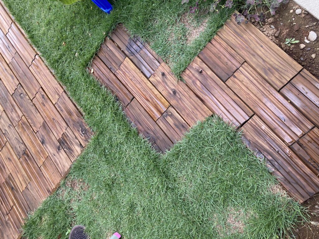 庭のDIYで木製タイルと芝が施工された様子。