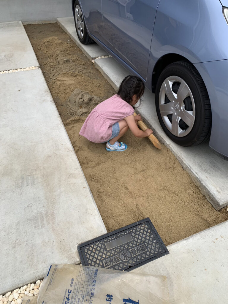 駐車場DIYの下地作りを手伝う女の子